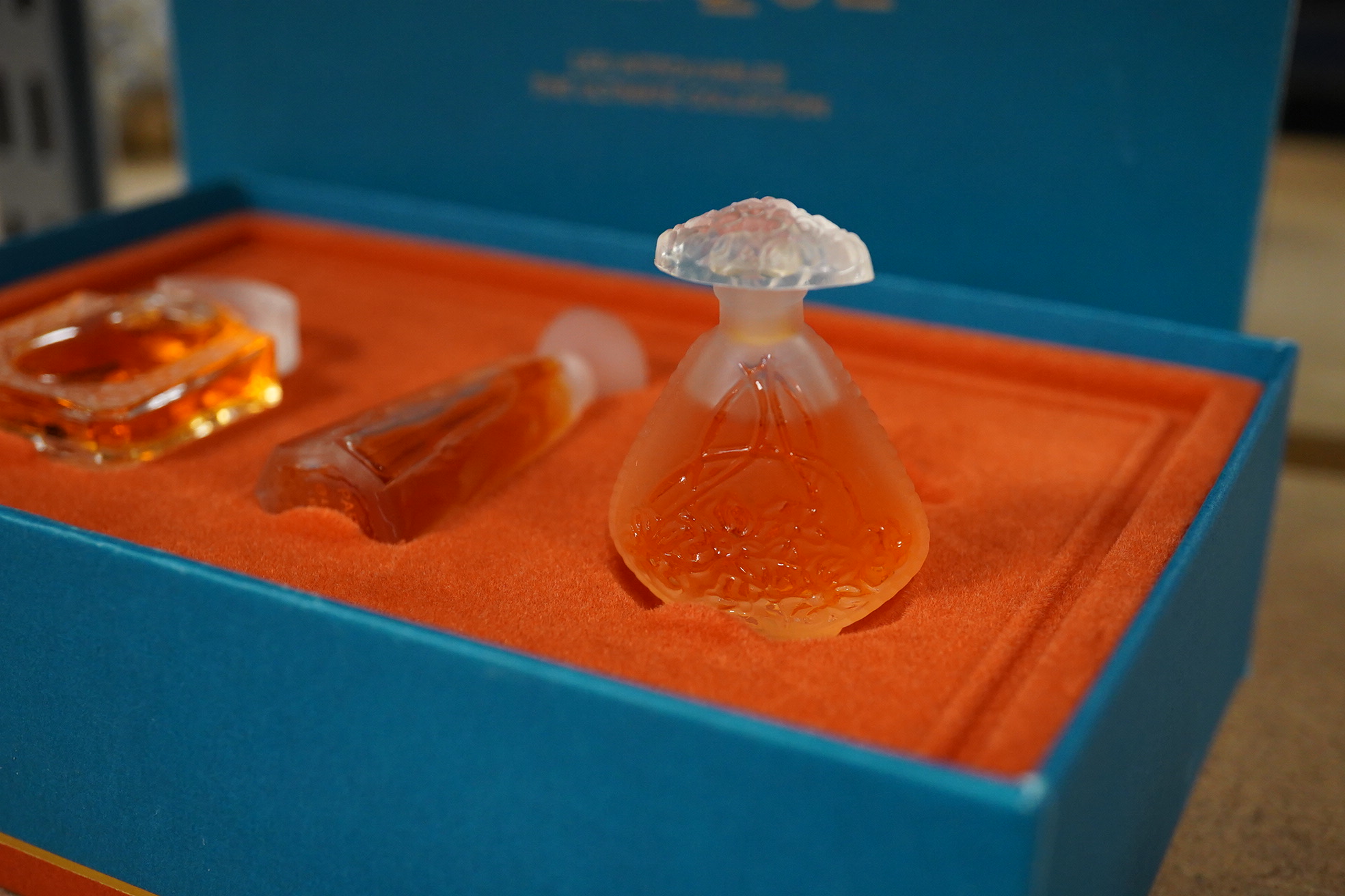A Lalique bird pin dish and a Lalique perfume trio, Les Introuvables, in original box, pin dish 9cm